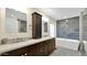 Modern bathroom with dual sinks, dark cabinetry, a soaking tub, and tile accents at 139 W Granada Rd, Phoenix, AZ 85003