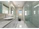 Bathroom with double sinks, marble countertops, tiled floors, walk-in glass shower, and lots of storage at 14749 E Pecos Rd, Gilbert, AZ 85295