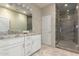 Elegant bathroom with double sink vanity, framed mirror, and walk-in shower with glass door at 14749 E Pecos Rd, Gilbert, AZ 85295