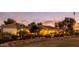 Charming single-story home with lush landscaping and warm exterior lighting at sunset at 14749 E Pecos Rd, Gilbert, AZ 85295