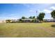 Expansive front yard view of a single story home, American flag, and well-maintained lawn at 14749 E Pecos Rd, Gilbert, AZ 85295