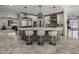 Kitchen island with seating, custom cabinets, stainless appliances, and pendant lighting at 14749 E Pecos Rd, Gilbert, AZ 85295