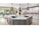 Kitchen island with double sinks, custom cabinets, stainless appliances, and pendant lighting at 14749 E Pecos Rd, Gilbert, AZ 85295