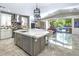 Bright kitchen boasts marble island, stainless steel appliances, and seamless indoor-outdoor living with views of the pool at 14749 E Pecos Rd, Gilbert, AZ 85295