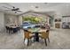 Open living space with multiple dining tables and large glass doors to outdoor entertaining space and pool at 14749 E Pecos Rd, Gilbert, AZ 85295