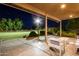 Inviting covered patio with stamped concrete and serene backyard views at nighttime at 14749 E Pecos Rd, Gilbert, AZ 85295