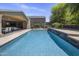 A backyard featuring a large in-ground pool, patio, and well-kept landscaping, blue skies at 14749 E Pecos Rd, Gilbert, AZ 85295