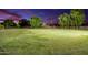 A large, well-maintained lawn with mature trees and a white fence at twilight at 14749 E Pecos Rd, Gilbert, AZ 85295