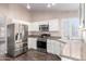 Well-lit kitchen featuring stainless steel appliances, white cabinets, and granite countertops at 1538 W Wagner Dr, Gilbert, AZ 85233