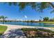 View of the lake with lush landscaping and a community dock at 1538 W Wagner Dr, Gilbert, AZ 85233