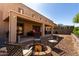 Enjoy outdoor relaxation in this backyard with a covered patio and cozy fire pit seating area at 18484 W Westfall Way, Surprise, AZ 85374