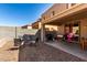 Relax and entertain in this backyard featuring a fire pit, BBQ grill, and covered patio area at 18484 W Westfall Way, Surprise, AZ 85374
