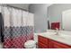 This bathroom has a patterned shower curtain, cabinet, and modern sink at 18484 W Westfall Way, Surprise, AZ 85374