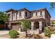 Charming two-story home featuring a tile roof, arched entry, and a well-maintained landscaped front yard at 18484 W Westfall Way, Surprise, AZ 85374