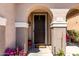 Close-up of the front door, showcasing the arched entryway, secure screen door, and charming welcome mat at 18484 W Westfall Way, Surprise, AZ 85374