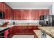 Stylish kitchen with wooden cabinetry, granite countertops, stainless steel appliances, and ample counter space for food preparation at 18484 W Westfall Way, Surprise, AZ 85374