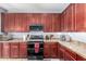 Gorgeous kitchen boasts granite countertops, wood cabinets, tile floors and modern appliances at 18484 W Westfall Way, Surprise, AZ 85374