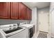Well-equipped laundry room features modern washer, dryer, and abundant cabinetry for organized storage solutions at 18484 W Westfall Way, Surprise, AZ 85374