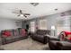 Spacious living room with comfortable seating, a ceiling fan, and a retro arcade game at 18484 W Westfall Way, Surprise, AZ 85374