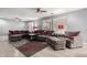 Comfortable living room with a sectional sofa, ceiling fans, and a stylish patterned rug at 18484 W Westfall Way, Surprise, AZ 85374