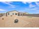 Spacious backyard featuring desert landscaping, a paver patio with firepit, and an artificial turf putting green at 18501 E Donato Dr, Gold Canyon, AZ 85118
