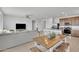 Open-concept living space with modern sofa, ceiling fan, and dining area adjacent to the kitchen at 18501 E Donato Dr, Gold Canyon, AZ 85118