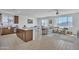 Open-concept living space with a kitchen island, dining area, and a comfortable seating area with large windows at 18501 E Donato Dr, Gold Canyon, AZ 85118