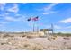 Community entrance sign for Entrada Del Oro with Arizona and American flags at 18501 E Donato Dr, Gold Canyon, AZ 85118