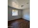 Comfortable bedroom featuring wood floors, a window, and natural light at 1907 W Gardenia Dr, Phoenix, AZ 85021