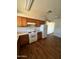 Well-lit kitchen with wooden cabinets, white appliances, and wood-look flooring at 1907 W Gardenia Dr, Phoenix, AZ 85021