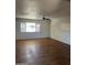 Spacious living room featuring wood floors, a large window with great natural light, and a ceiling fan at 1907 W Gardenia Dr, Phoenix, AZ 85021