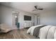 This bedroom features wood floors, a ceiling fan, and an ensuite bathroom with a tiled shower at 19690 W Marshall Ave, Litchfield Park, AZ 85340