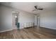 Spacious bedroom featuring wood floors, a ceiling fan, and a dresser with doorway leading to the bathroom at 19690 W Marshall Ave, Litchfield Park, AZ 85340
