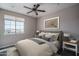 This bedroom features wood floors, a ceiling fan, and a view of the surrounding neighborhood at 19690 W Marshall Ave, Litchfield Park, AZ 85340