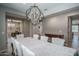 Dining room view with chandelier, table set for eight, and a peek into other rooms at 19690 W Marshall Ave, Litchfield Park, AZ 85340