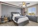 This bedroom has gray walls, a ceiling fan, a wooden desk, a large dresser, and a cushioned chair at 19943 E Strawberry Dr, Queen Creek, AZ 85142
