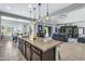 An open kitchen concept with an island, a view into the great room and access to a covered patio at 19943 E Strawberry Dr, Queen Creek, AZ 85142