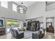Open-concept living room with high ceilings, modern lighting, and seamless access to the kitchen and pool area at 19943 E Strawberry Dr, Queen Creek, AZ 85142