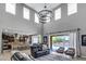 Open-concept living room with high ceilings, modern lighting, and seamless access to the kitchen and pool area at 19943 E Strawberry Dr, Queen Creek, AZ 85142