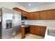 Well-lit kitchen featuring wood cabinets, stainless steel appliances, and neutral countertops, offering a functional cooking space at 204 S Valle Verde --, Mesa, AZ 85208