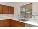 Bright kitchen showcasing wood cabinetry, a double sink beneath a window, and contemporary backsplash tiling, blending style and utility at 204 S Valle Verde --, Mesa, AZ 85208