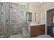 Spacious bathroom featuring stone shower with glass door and double sink vanity with granite countertop at 21532 N 65Th Ave, Glendale, AZ 85308