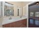 Bathroom featuring double sink vanity with granite countertop, wood cabinets, and decorative mirrors at 21532 N 65Th Ave, Glendale, AZ 85308