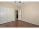 Cozy bedroom features wood floors, neutral walls and a large closet with sliding doors at 21532 N 65Th Ave, Glendale, AZ 85308