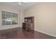 Comfortable bedroom features hardwood floors, a dark wooden desk, and a bright window at 21532 N 65Th Ave, Glendale, AZ 85308
