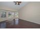 A bedroom has a fan and a lot of natural light from the many windows and wood floors at 21532 N 65Th Ave, Glendale, AZ 85308