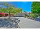 House exterior with a concrete driveway, desert landscaping, and mature trees at 21532 N 65Th Ave, Glendale, AZ 85308