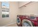 Laundry room features side-by-side washer and dryer, tile floor, and storage cabinets at 21532 N 65Th Ave, Glendale, AZ 85308