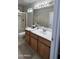 Bathroom with wooden cabinets, white countertop, large mirror, and a shower with gold trim showcases elegance at 2221 E Union Hills Dr # 157, Phoenix, AZ 85024