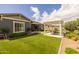 Lush backyard features artificial turf, a covered patio with outdoor seating, and manicured landscaping at 22670 E Russet Rd, Queen Creek, AZ 85142